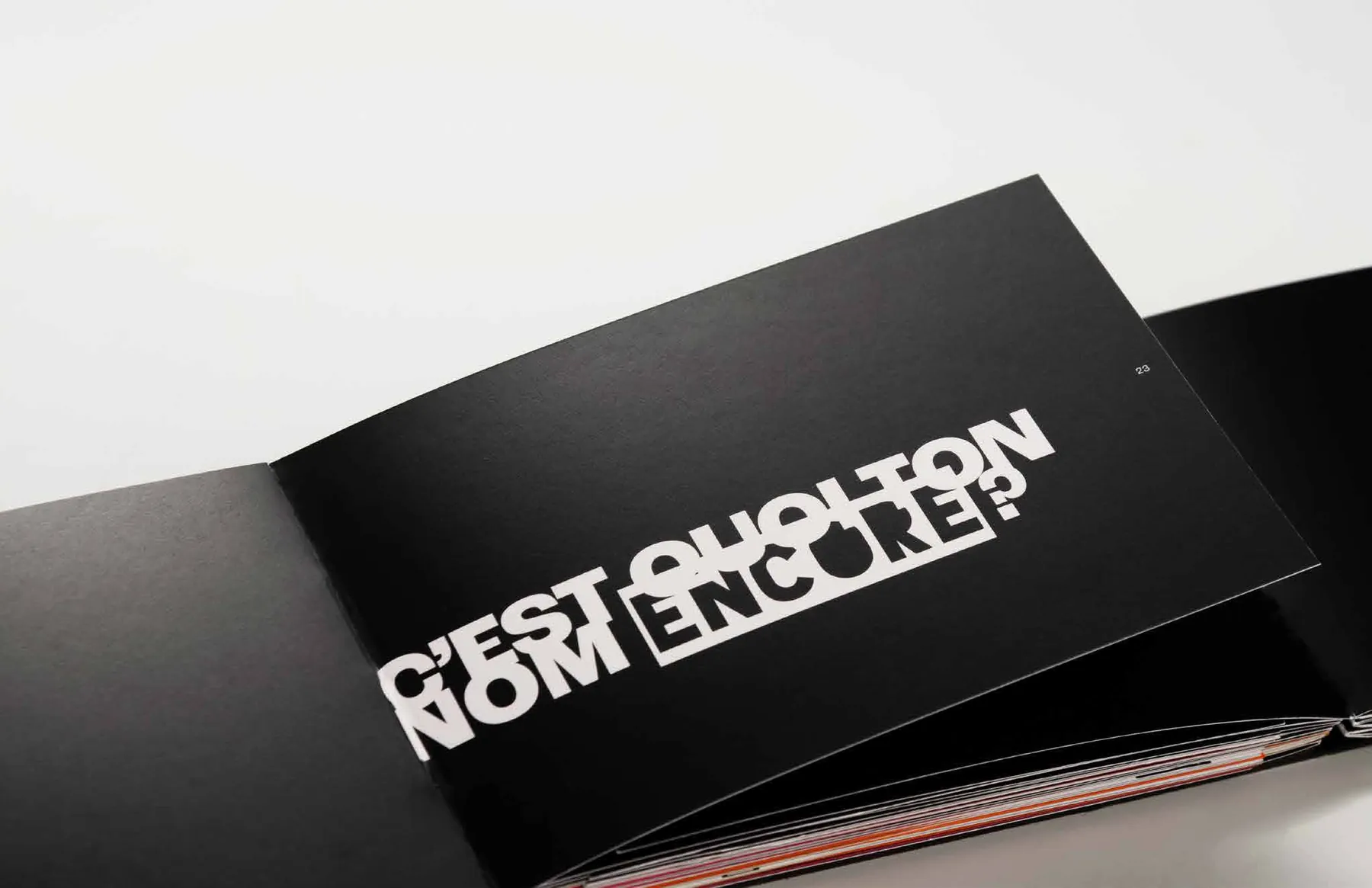 Livre ouvert à couverture noire portant en lettres blanches « C’est quoi ton nom encore? ».