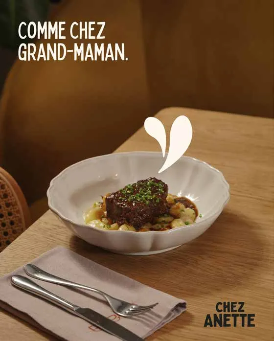 Plat mijoté dressé sur une table, avec le texte « Comme chez grand-maman » et le logo Chez Anette.
